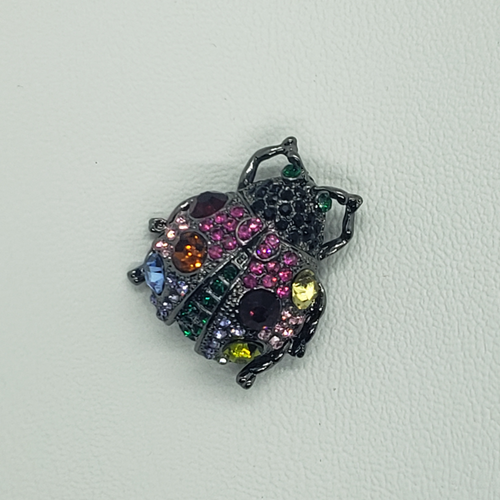 Incrusted multi colored crystals lady bug pin. Can be worn on clothes, bags or any other fabric items.